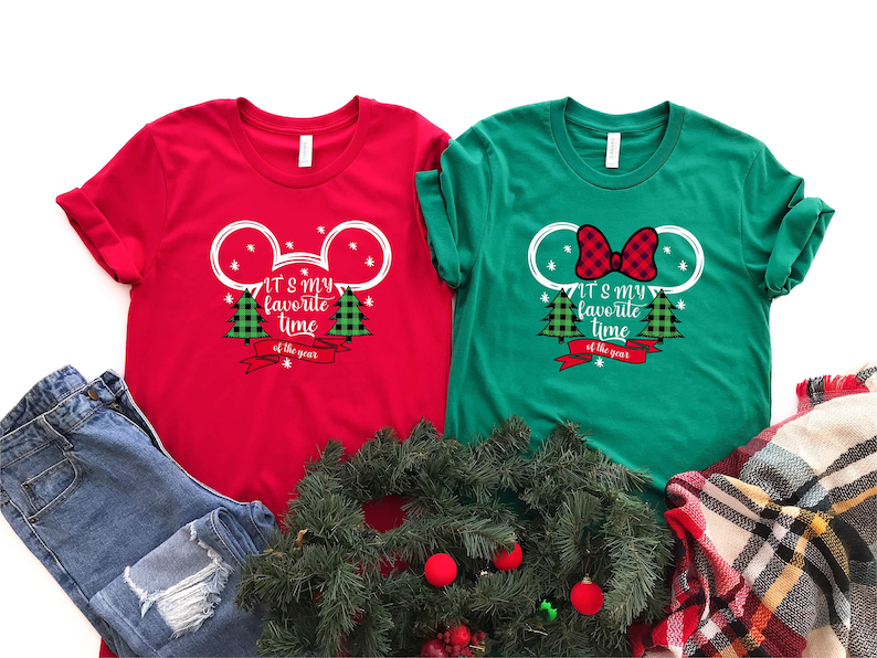 Puede incluir: Dos camisetas de Navidad rojas y verdes con un dise&ntilde;o de cabeza de Mickey Mouse. El texto en las camisetas dice "It's my favorite time of the year".
