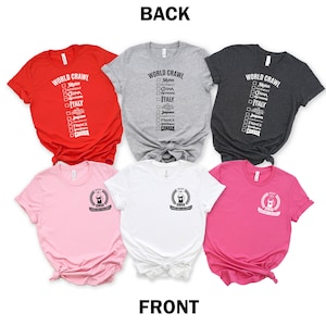 May include: Five t-shirts in different colors, red, gray, dark gray, pink, and white. The back of the red, gray, and dark gray shirts have the text "WORLD CRAWL" with a checklist of countries. The front of the pink, white, and gray shirts have a graphic of a laurel wreath with the text "I SPEAK WORLD CRAWL & EAT GOOD FOOD".