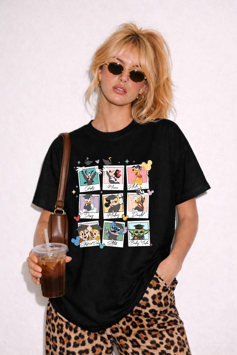 May include: Black t-shirt featuring nine framed images of Disney characters, including Goofy, Minnie, Pluto, Daisy, Mickey, Donald, Chip and Dale, Stitch, and Baby Yoda. The characters are wearing graduation caps. The shirt is worn by a person.