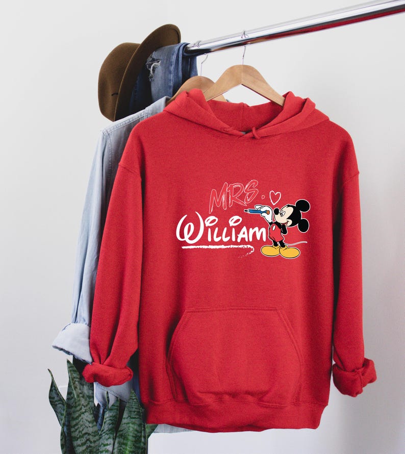 May include: Red hooded sweatshirt with a white Mickey Mouse design and the text "MRS. (heart) WILLIAM" in pink.