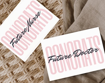 May include: Two white cards with pink lettering that reads "Congrats Future Nurse" and "Congrats Future Doctor". The cards are on a woven brown surface and a brown fabric.