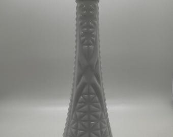Op de afbeelding: Een hoge, witte vaas in vintage-stijl met een uitlopende bovenkant en een gestructureerd, geometrisch patroon. De vaas is gemaakt van ondoorzichtig glas en heeft een slanke, conische vorm. De vaas is ongeveer 30 cm hoog.