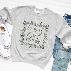 Może przedstawiać: Szara bluza z zielonym wzorem akwarelowym z tekstem "be kind to plants".