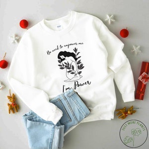 May include: White sweatshirt with a black and white illustration of a woman with the text "No need to empower me I'm Power".
