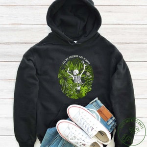 May include: Black hoodie featuring a green and white graphic of a skeleton surrounded by plants. The graphic reads "All my friends are plants".