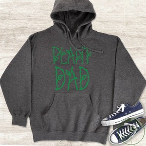 May include: A dark grey hooded sweatshirt with a green graphic that says "Plant Dad".