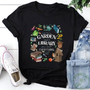 May include: Black t-shirt with a white graphic design featuring a garden and library with the text "If you have a garden and a library, you have everything you need - Cicero".