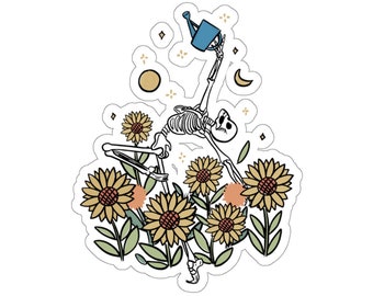 Pode incluir: Um desenho a preto e branco de um esqueleto a regar girassóis com um regador azul. O esqueleto está numa pose de ioga, a levantar o regador. Os girassóis estão em flor e têm pétalas amarelas e centros castanhos. Há estrelas e uma lua crescente no fundo.
