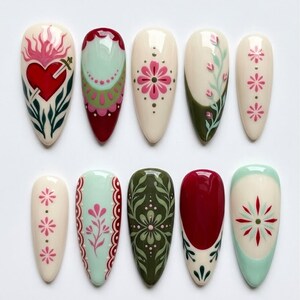 May include: A set of ten almond-shaped press-on nails featuring intricate hand-painted designs. The collection includes motifs such as a red sacred heart with a sword, floral patterns, geometric borders, and botanical vines in shades of cream, red, olive green, and mint.