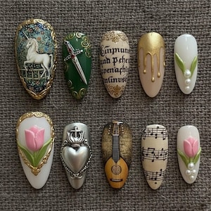 May include: A collection of ten intricately designed nail art pieces. Designs include a unicorn, a sword, script, gold drips, leaves with pearls, a tulip, a heart with a crown, a lute, musical notes, and another tulip with pearls.