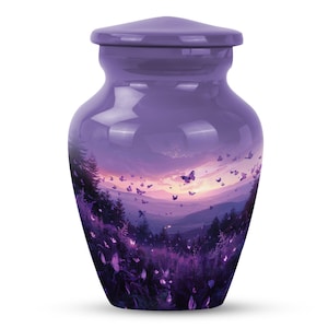 May include: Purple ceramic cremation urn with a sunset and butterfly design. The urn features a landscape scene with a mountain range, trees, and a field of flowers. Butterflies are flying in the sky above the mountains.