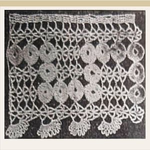 May include: Close-up of a white, crocheted lace trim. The trim features a repeating pattern of circular elements connected by a delicate, openwork design. The bottom edge has a scalloped border. The lace is likely cotton or a similar fiber.