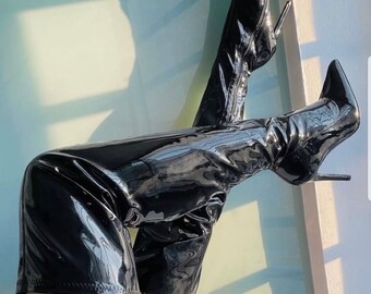 May include: A pair of black patent leather thigh-high boots with stiletto heels.
