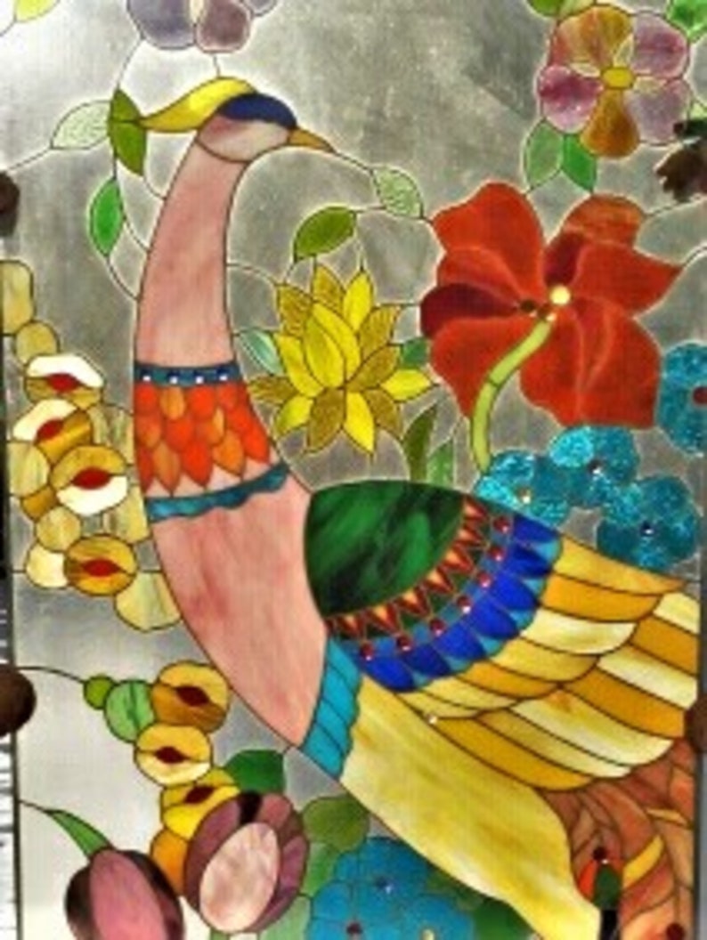 May include: Stained glass panel featuring a colorful peacock with a pink neck, orange and blue accents, and yellow and blue tail feathers. The artwork includes flowers in red, yellow, and blue, with green leaves and a silver background. Decorative art.