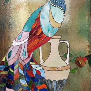 May include: Stained glass panel featuring a colorful peacock perched on a vase. The peacock has a white head, turquoise body, and a vibrant tail with red, orange, blue, and green feathers. The background is a textured, golden-green.
