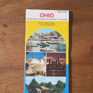 May include: A vintage Sunoco DX gas station map of Ohio from 1972-1973. The map includes city maps of Cincinnati, Cleveland, Akron, Canton, Columbus, Dayton, Toledo, and Youngstown. The map features four images of scenic locations in Ohio, including a lake with boats, a mountain range, a city skyline, and a watermill.
