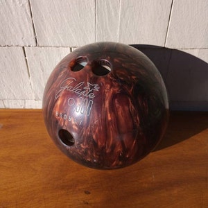 May include: A brown and black bowling ball with a white star and the text "Galaxie 300" and the number "800547".