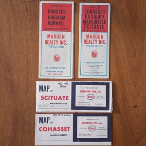 May include: Four vintage maps of towns in Massachusetts. The maps are printed on white paper with blue and red text. The maps are titled "Hanover, Hingham, Norwell", "Cohasset, Duxbury, Marshfield, Scituate", "Scituate", and "Cohasset".