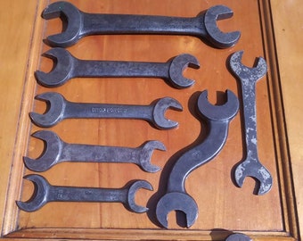 Op de afbeelding: Een set van acht vintage sleutels in verschillende maten en vormen. De sleutels zijn gemaakt van metaal en hebben een zwarte afwerking. Sommige sleutels hebben de tekst "DROP FORGED" erop gedrukt.
