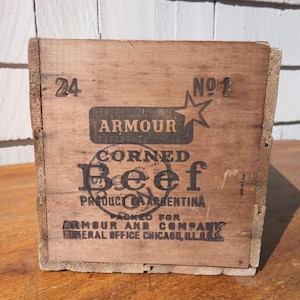May include: A vintage wooden crate with the text "24" and "NO1" printed on the front. The crate is labeled "ARMOUR CORNED Beef PRODUCT OF ARGENTINA" and "PACKED FOR ARMOUR AND COMPANY GENERAL OFFICE CHICAGO, ILLS."