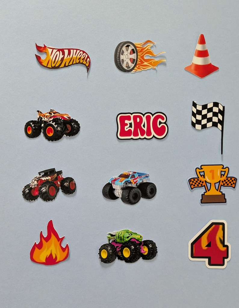 May include: A collection of colorful Hot Wheels-themed stickers. Includes a flaming tire, a red and white traffic cone, monster trucks, a checkered flag, a trophy, a flame, and the name "ERIC".