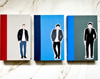 Puede incluir: Tres portadas de libros con diferentes ilustraciones de personajes. La primera portada es gris con una franja roja y presenta a un hombre con una chaqueta negra, camisa blanca y pantalones vaqueros azules. La segunda portada es azul con una franja azul oscuro y presenta a un hombre con una chaqueta de cuero negra, camisa blanca y pantalones vaqueros negros. La tercera portada es gris con una franja azul y presenta a un hombre con un traje negro y camisa blanca. El texto en las portadas dice "Sean", "Liam" y "Tobias".