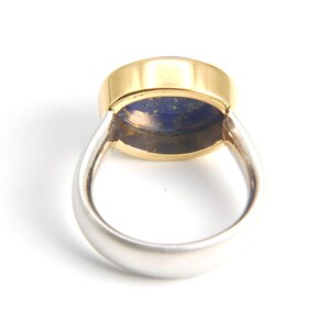 May include: A gold and silver ring with a blue lapis lazuli stone set in the center.