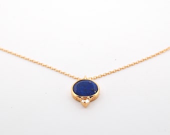 Golden necklace with a round lapis lazuli pendant and small topaz