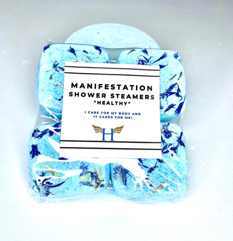 K&ouml;nnte beinhalten: Vier blaue Duschdampfer mit wei&szlig;en und blauen Bl&uuml;tenbl&auml;ttern, verpackt in durchsichtigem Plastik. Das Etikett lautet "Manifestation Shower Steamers "Healthy" I care for my body and it cares for me! H"