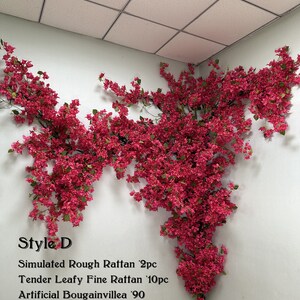 May include: Artificial bougainvillea plant with pink flowers, displayed against a white wall. The plant is part of a decorative set that includes simulated rough rattan and fine rattan.
