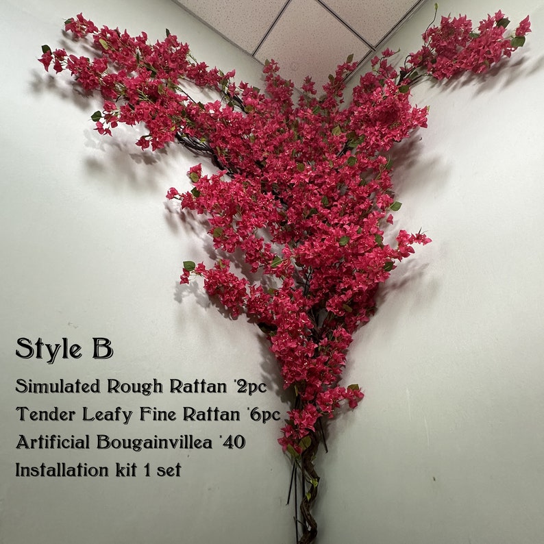May include: A pink artificial bougainvillea vine with green leaves, hanging from a corner of a white wall. The vine is made of plastic and has a realistic appearance. The text "Style B" is written below the vine, along with a list of materials and quantities: "Simulated Rough Rattan 2pc", "Tender Leafy Fine Rattan 6pc", "Artificial Bougainvillea '40", and "Installation kit 1 set".