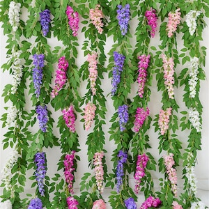 May include: Artificial wisteria vines with green leaves and cascading flower clusters in shades of white, purple, pink, and peach. These decorative vines are ideal for adding a touch of nature to any space.