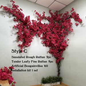 May include: Artificial bougainvillea vine with pink flowers, displayed on a white wall. The vine is made of plastic and has a realistic appearance. The text "Style C" is written on the wall, along with the following information: "Simulated Rough Rattan '2pc", "Tender Leafy Fine Rattan '8pc", "Artificial Bougainvillea '60", and "Installation kit 1 set".
