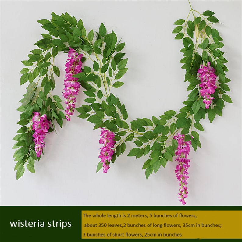 May include: Artificial wisteria strips with green leaves and vibrant pink flowers. The garland is 2 meters long and features 5 bunches of flowers, with approximately 350 leaves. The text "wisteria strips" is visible.