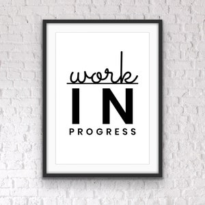 May include: Black and white framed print with the text "work in progress" in a modern font.