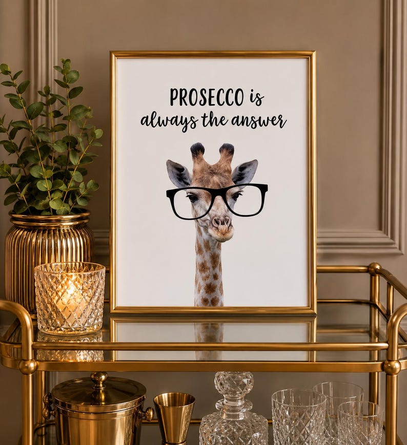 May include: A framed wall art print featuring a realistic giraffe wearing large black-rimmed glasses. The text above the giraffe reads, "PROSECCO is always the answer" in a combination of bold sans-serif and elegant script black lettering.
