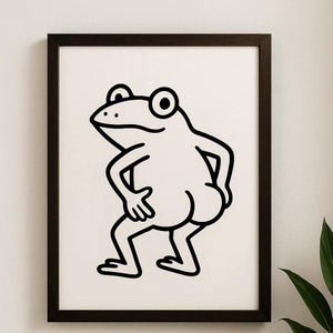 May include: Framed art print with a black and white cartoon frog illustration. The frog is depicted in a humorous pose, drawn with bold black lines on a white backdrop. The print is encased in a dark brown wooden frame.