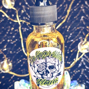 May include: A clear glass bottle with a black dropper top and a yellow liquid inside. The bottle has a label with the text "The Ginger Witch Haus" and "The Happiness" in a black and yellow font.