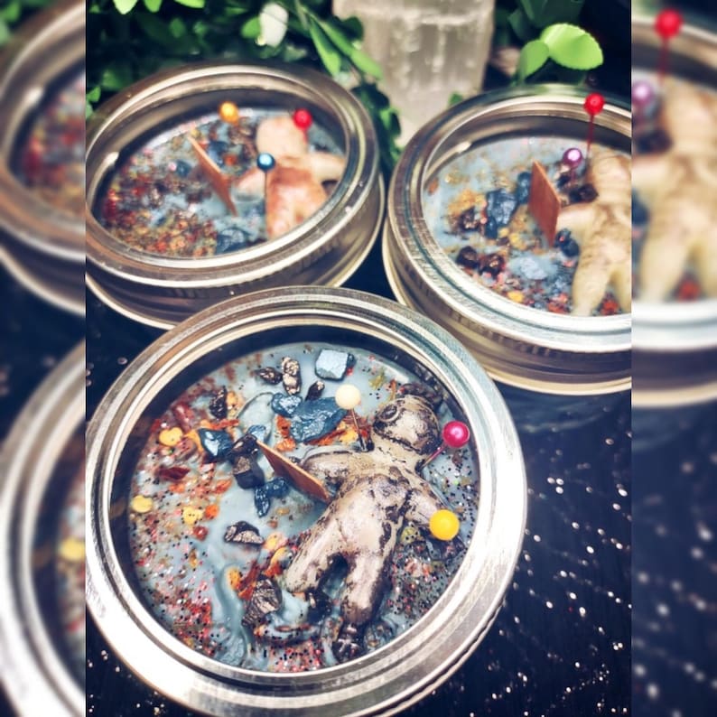 May include: Three jar candles with a blue wax base, each containing a small figurine and colorful decorative elements. The candles are in clear glass jars with silver lids. The overall aesthetic is whimsical and decorative.