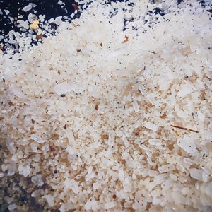 May include: Close-up of a pile of white, fine-grained salt crystals.