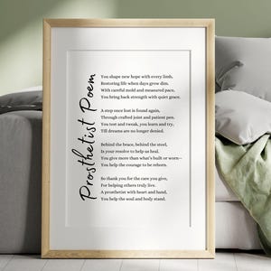 May include: Framed print with a light wood finish. The print features a poem titled "Prosthetist Poem" in elegant script. The poem's text is in black against a white background. The frame is displayed on a neutral-toned sofa with pillows and a green blanket.