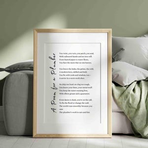 Può includere: Una stampa incorniciata con una cornice in legno chiaro. La stampa presenta una poesia intitolata "A Poem for a Plumber" in scrittura nera. I versi della poesia sono centrati su uno sfondo bianco, con uno sfondo verde tenue.