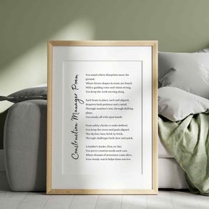 May include: A framed print featuring a poem titled "Construction Manager Poem" in elegant script. The poem is printed on a white background within a light wood frame. The artwork is displayed against a neutral-toned backdrop, suggesting a home decor theme.