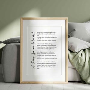 May include: A framed print with a light wood frame. The print features a poem titled "A Poem for an Internist" in black script. The background is white, and the print is displayed on a couch with pillows and a green blanket.