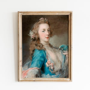 Puede incluir: Una pintura pastel enmarcada de una mujer con un vestido azul, un collar de perlas blancas y un pájaro azul en el hombro. Lleva una corona de flores en el pelo.