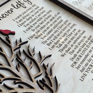 May include: A wooden sign with a carved tree and a red cardinal. The sign features a poem about love and loss, with the text "I never left you".