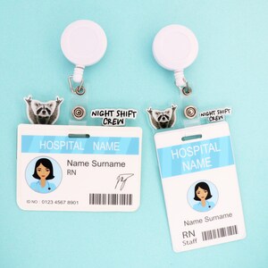 Op de afbeelding: Twee witte intrekbare badgehouders met een wasbeerbedel en de tekst "NIGHT SHIFT CREW". Elke badgehouder heeft een witte ID-badge met een blauwe streep, een verpleegsterillustratie en de tekst "HOSPITAL NAME". Op &eacute;&eacute;n badge staat "RN", op de andere staat "Staff".