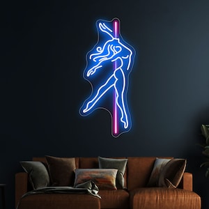 K&ouml;nnte beinhalten: Neon-Schild mit einer blauen Silhouette einer Person, die um eine rosa Stange tanzt. Das Schild ist an einer dunkelblauen Wand &uuml;ber einem braunen Sofa angebracht.