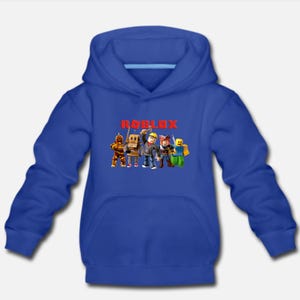 May include: A royal blue hooded sweatshirt with the word "ROBLOX" printed in red letters. The sweatshirt features a graphic of five cartoon characters from the popular online game Roblox.