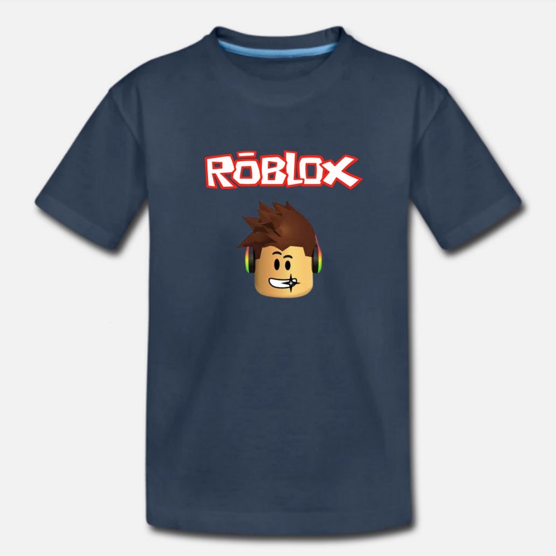 Puede incluir: Una camiseta azul marino con la palabra "ROBLOX" en letras rojas y un personaje de dibujos animados con auriculares.